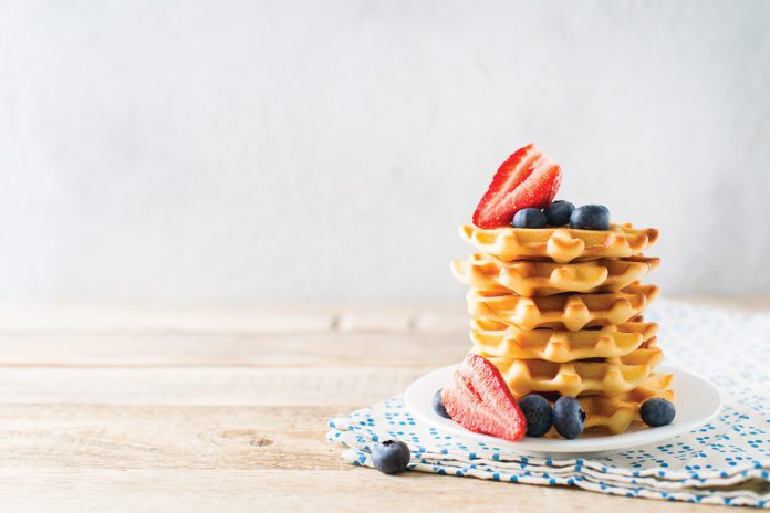 Stack of waffles with blueberries and strawberries on grey backg Waffle recipes